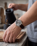 Clicöt Atlas 41mm watch in grey and brown on a man's left wrist, everyday lifestyle photo