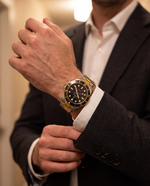 Clicöt Aurora 42mm watch in black, gold and silver on the left wrist, everyday lifestyle photo