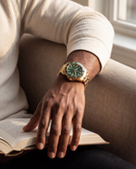 Close-up of the Clicöt Eclipse 42mm watch in green and gold on the left wrist