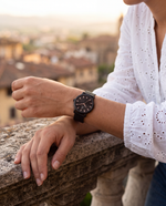 Close-up of the Clicöt Erebus 36mm watch in black on a woman's left wrist