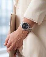 Clicöt Eros 36mm watch in black and silver on a woman's left wrist, everyday lifestyle photo