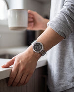 Close-up of the Clicöt Eros 36mm watch in black and silver on a woman's left wrist