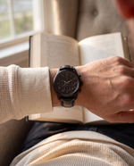 Clicöt Hades 42mm watch in black on a man's left wrist, everyday lifestyle photo