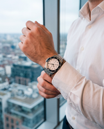 Clicöt Halo 42mm watch in black, white and silver on the left wrist, everyday lifestyle photo