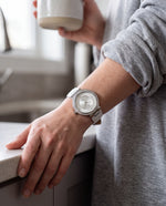 Clicöt Heaven 36mm women's watch in white, worn on a woman's left wrist