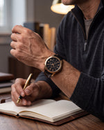 Clicöt Helios 42mm watch in black and gold on a man's left wrist, everyday lifestyle photo
