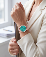 Clicöt Hestia 36mm women's watch in teal and rose gold, worn on a woman's left wrist