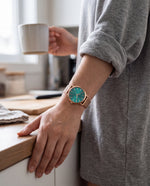 Clicöt Hestia 36mm watch in teal and rose gold on a woman's left wrist, everyday lifestyle photo