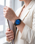 Close-up of the Clicöt Hypnos 36mm watch in black and blue on a woman's left wrist