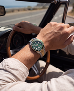 Clicöt Infinity 42mm unisex watch in green, gold and silver, worn on the left wrist
