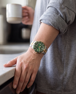 Close-up of the Clicöt Infinity 42mm watch in green, gold and silver on the left wrist