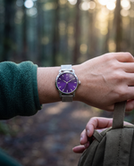 Close-up of the Clicöt Iris 36mm watch in purple and silver on a woman's left wrist