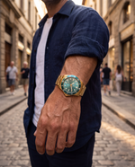 Clicöt Leo 42mm watch in teal and gold on the left wrist, everyday lifestyle photo