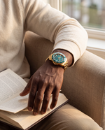 Close-up of the Clicöt Leo 42mm watch in teal and gold on the left wrist