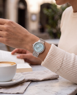 Clicöt Liane 36mm watch in blue and silver on a woman's left wrist, everyday lifestyle photo