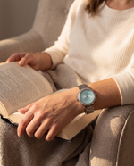 Close-up of the Clicöt Liane 36mm watch in blue and silver on a woman's left wrist