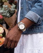 Clicöt Lumen 42mm watch in black, white, gold and silver on the left wrist, everyday lifestyle photo