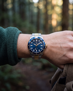 Clicöt Meridian 42mm unisex watch in navy, gold and silver, worn on the left wrist