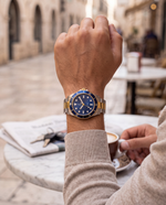Clicöt Meridian 42mm watch in navy, gold and silver on the left wrist, everyday lifestyle photo