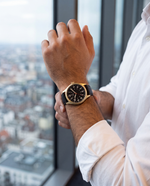 Clicöt Moros 41mm men's watch in black and gold, worn on a man's left wrist
