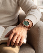 Close-up of the Clicöt Morpheus 41mm watch in green, brown and rose gold on a man's left wrist