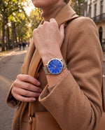 Clicöt Oceanus 36mm watch in blue and silver on a woman's left wrist, everyday lifestyle photo