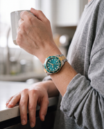 Clicöt Orion 42mm unisex watch in teal, gold and silver, worn on the left wrist