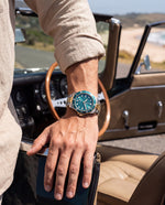 Close-up of the Clicöt Orion 42mm watch in teal, gold and silver on the left wrist