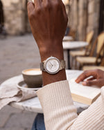 Clicöt Pandora 36mm watch in white and silver on a woman's left wrist, everyday lifestyle photo
