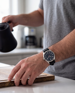 Close-up of the Clicöt Poseidon 41mm watch in navy and black on a man's left wrist