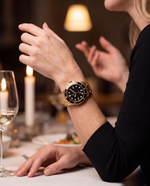 Clicöt Radiant 42mm watch in black and gold on the left wrist, everyday lifestyle photo