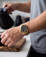 Close-up of the Clicöt Radiant 42mm watch in black and gold on the left wrist