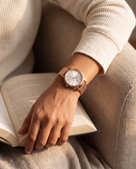 Clicöt Rhea 36mm women's watch in white and rose gold, worn on a woman's left wrist