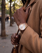 Clicöt Rhea 36mm watch in white and rose gold on a woman's left wrist, everyday lifestyle photo