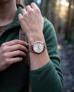 Close-up of the Clicöt Rhea 36mm watch in white and rose gold on a woman's left wrist