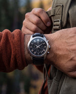 Clicöt Robin 42mm watch in black and silver on a man's left wrist, everyday lifestyle photo