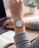 Close-up of the Clicöt Selene 36mm watch in silver on a woman's left wrist