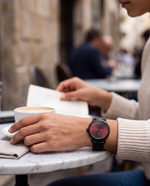 Clicöt Siren 36mm watch in black and red on a woman's left wrist, everyday lifestyle photo