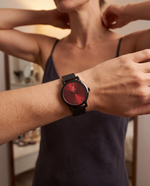 Close-up of the Clicöt Siren 36mm watch in black and red on a woman's left wrist