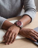 Clicöt Solara 42mm watch in red and silver on the left wrist, everyday lifestyle photo