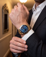 Clicöt Solstice 42mm watch in navy and gold on the left wrist, everyday lifestyle photo