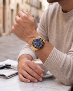 Close-up of the Clicöt Solstice 42mm watch in navy and gold on the left wrist