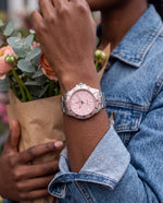 Clicöt Stella 42mm watch in pink and silver on the left wrist, everyday lifestyle photo