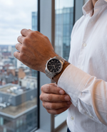 Clicöt Tristan 42mm watch in black and silver on a man's left wrist, everyday lifestyle photo